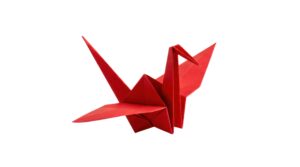 Czerwony papierowy żuraw origami na białym tle
