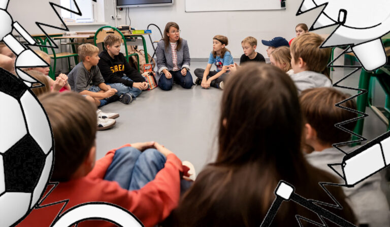 Zdjęcie przedstawia dzieci wraz z nauczycielem siedzące w kółku na podłodze podczas zajęć.